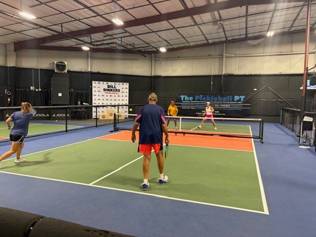 Players rallying on an indoor court during camp